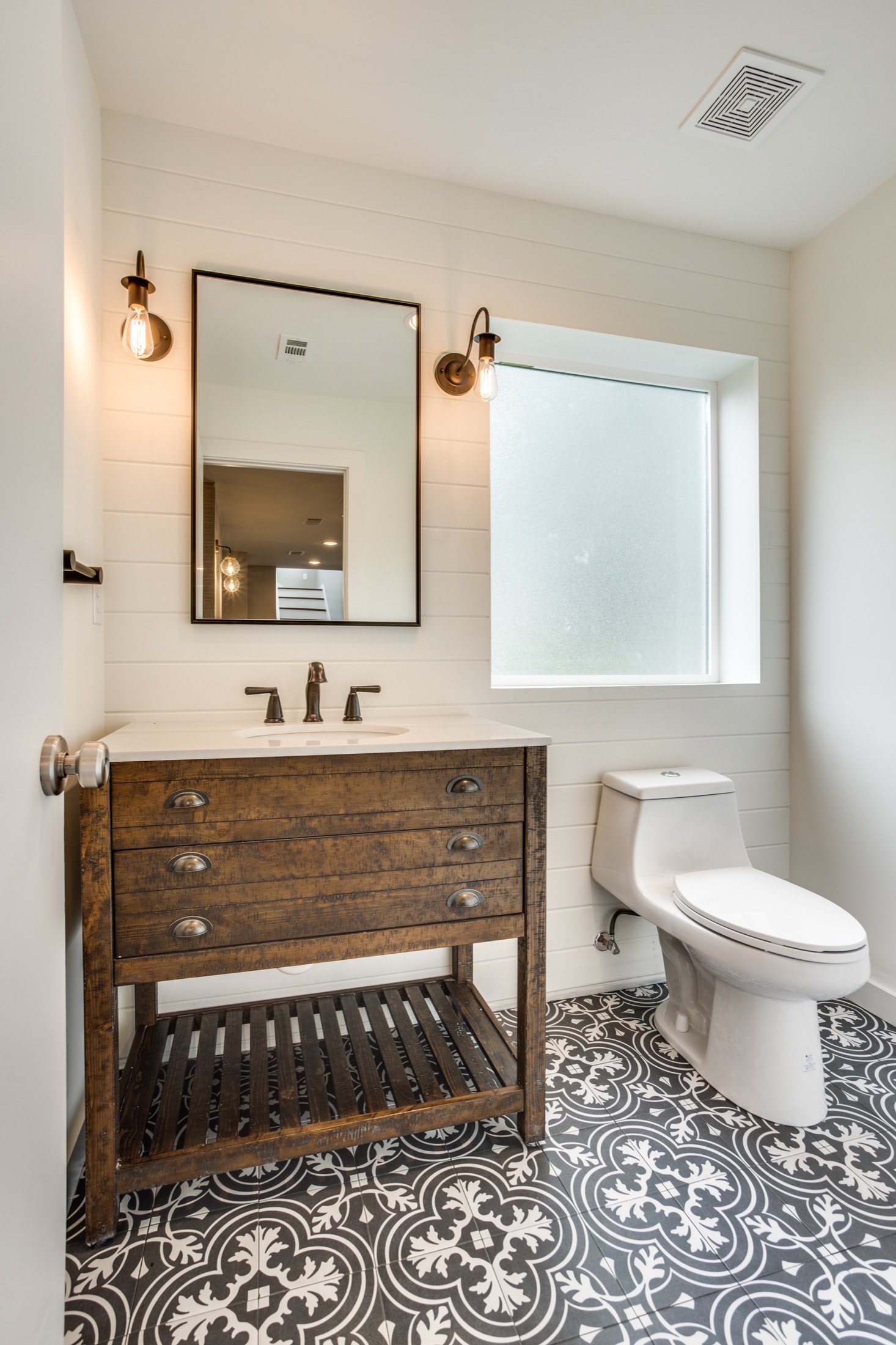 Powder room with a rustic wood vanity, white shiplap and patterned floor tile