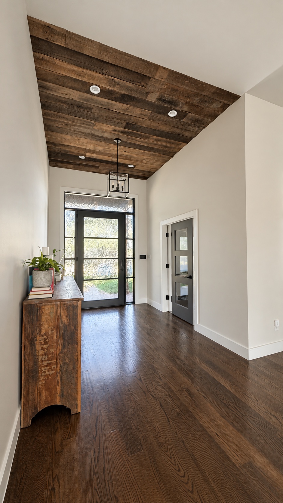 Digitally refined entry with a dark wood ceiling, glass front door, and closed office door