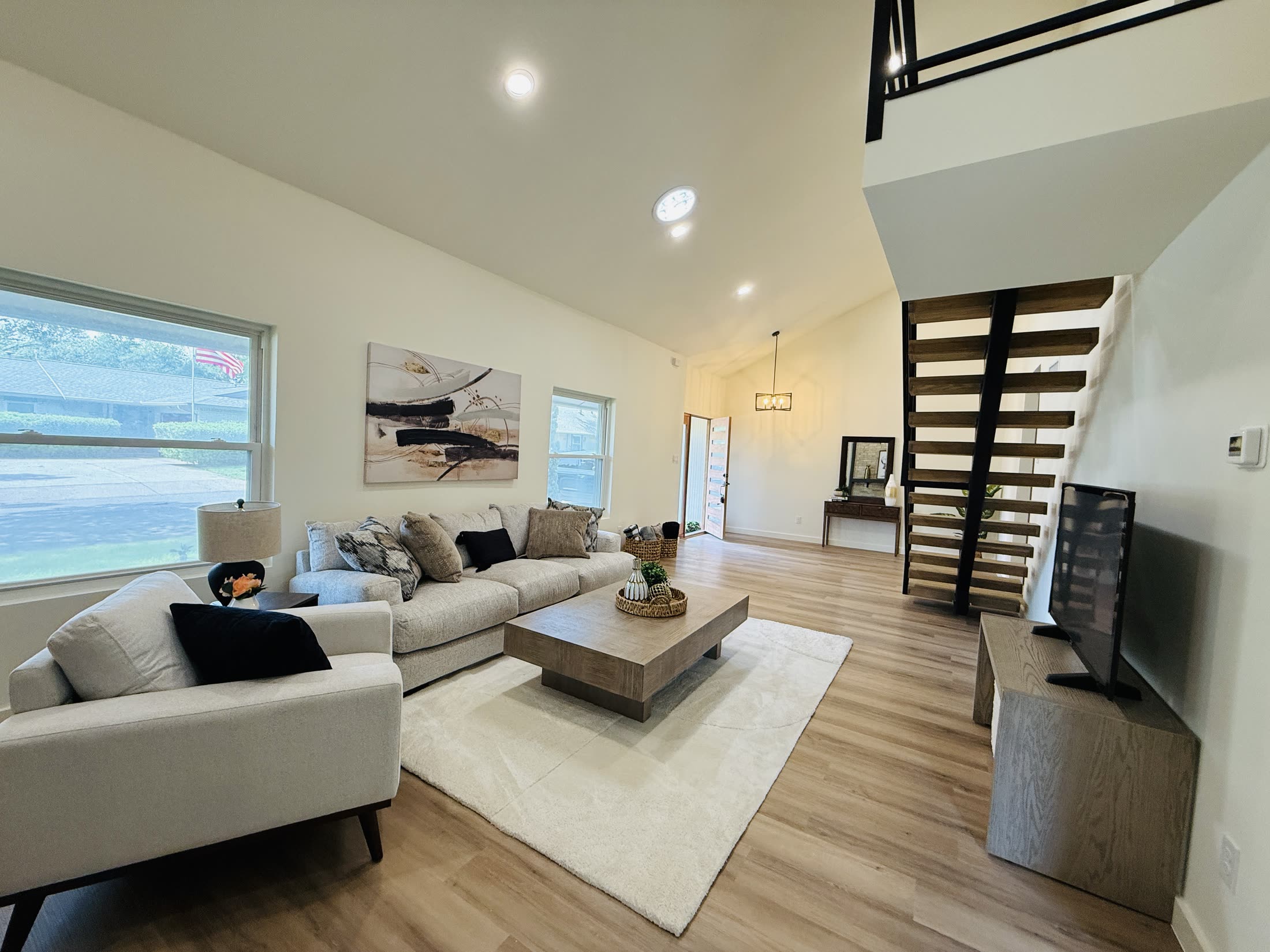 Contemporary living room with an open wood-and-metal staircase