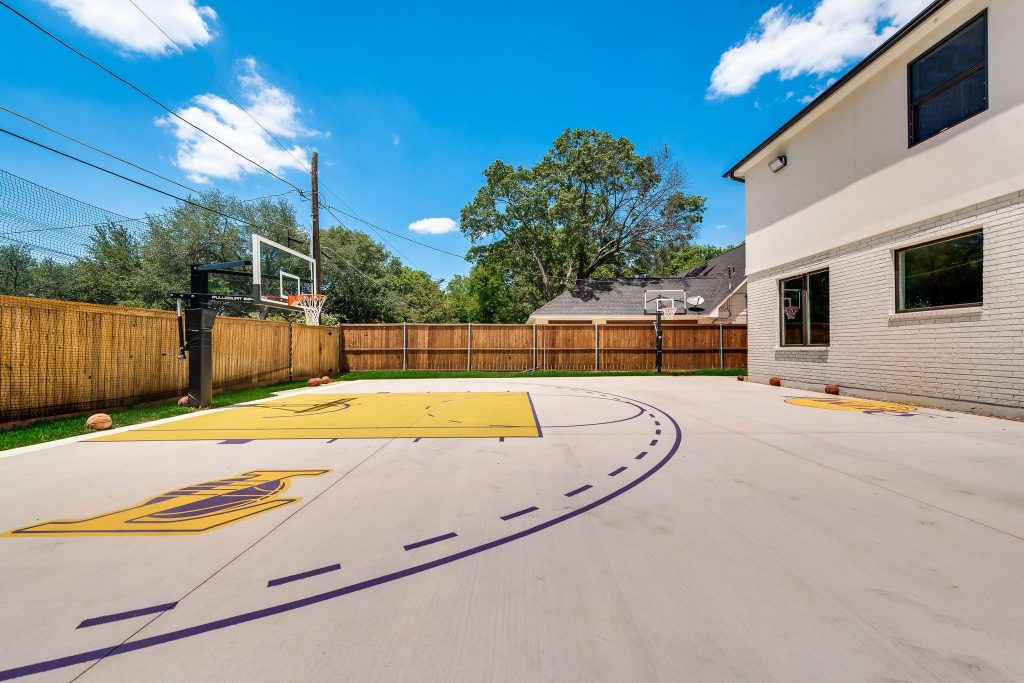 Custom backyard basketball court beside a remodeled home