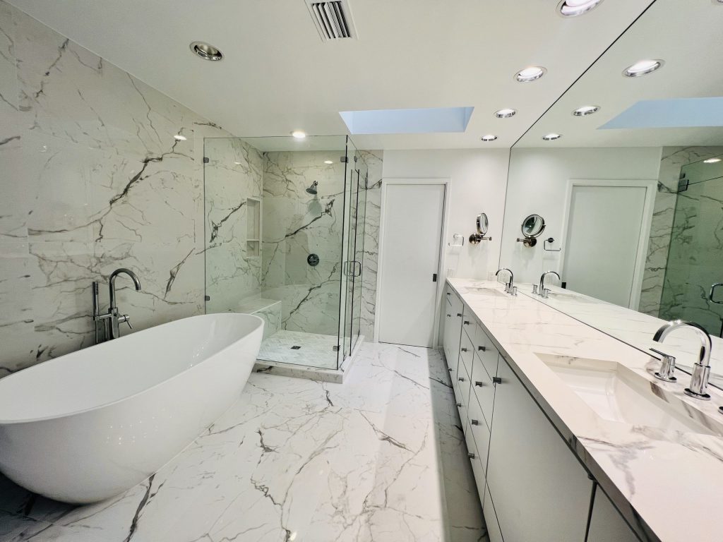 White marble bathroom with soaking tub and glass shower