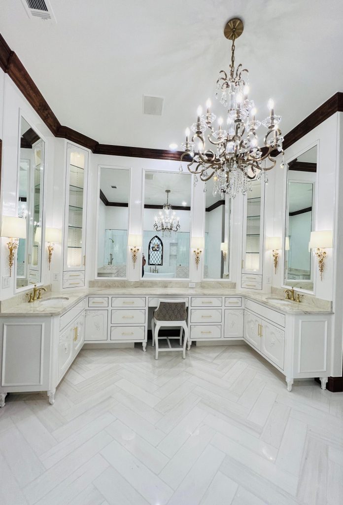 Bright primary bathroom with chandelier and double vanities