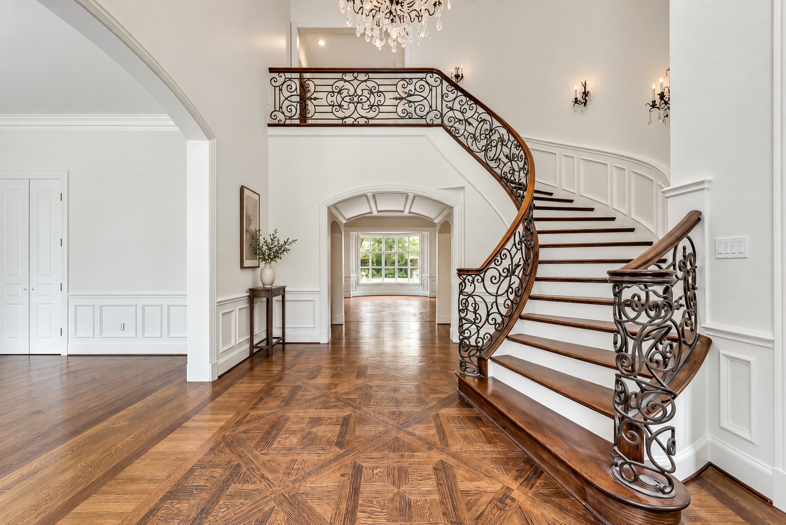 Finished entry hall with sculptural staircase and wood floors