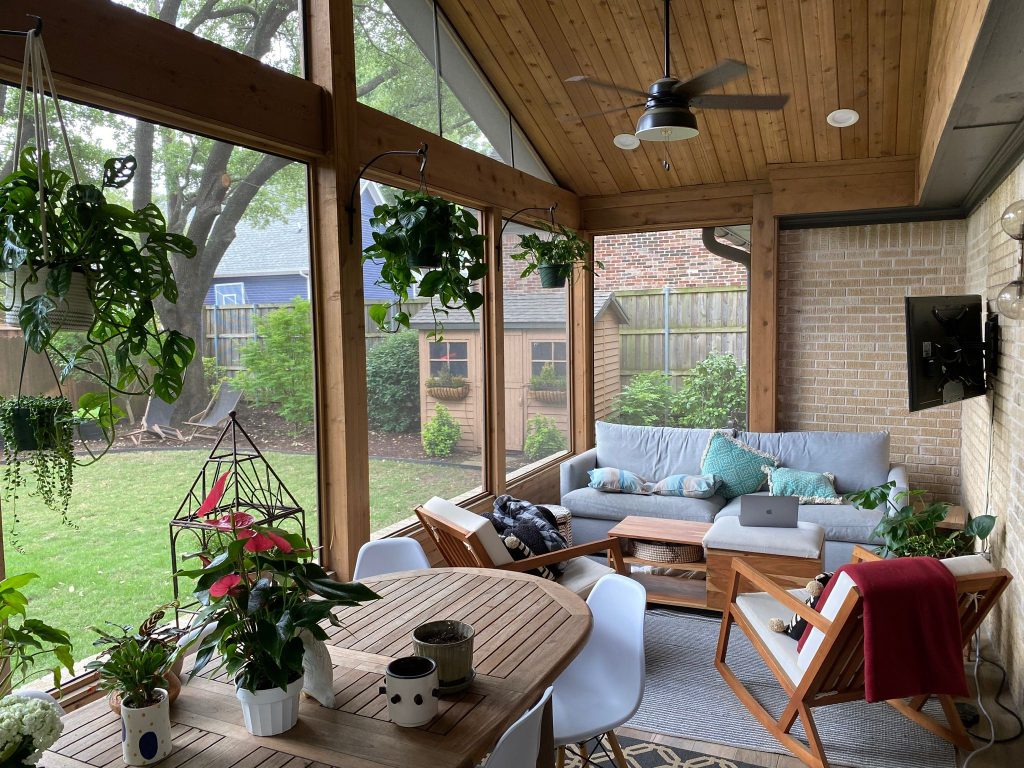 Screened outdoor living room overlooking a leafy backyard