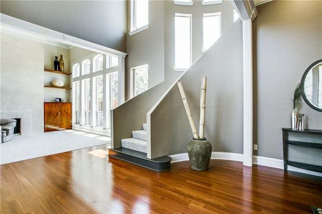 Light-filled foyer with wood floors and staircase