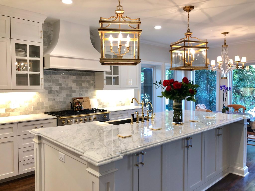 Kitchen with a white stone island and lantern pendants
