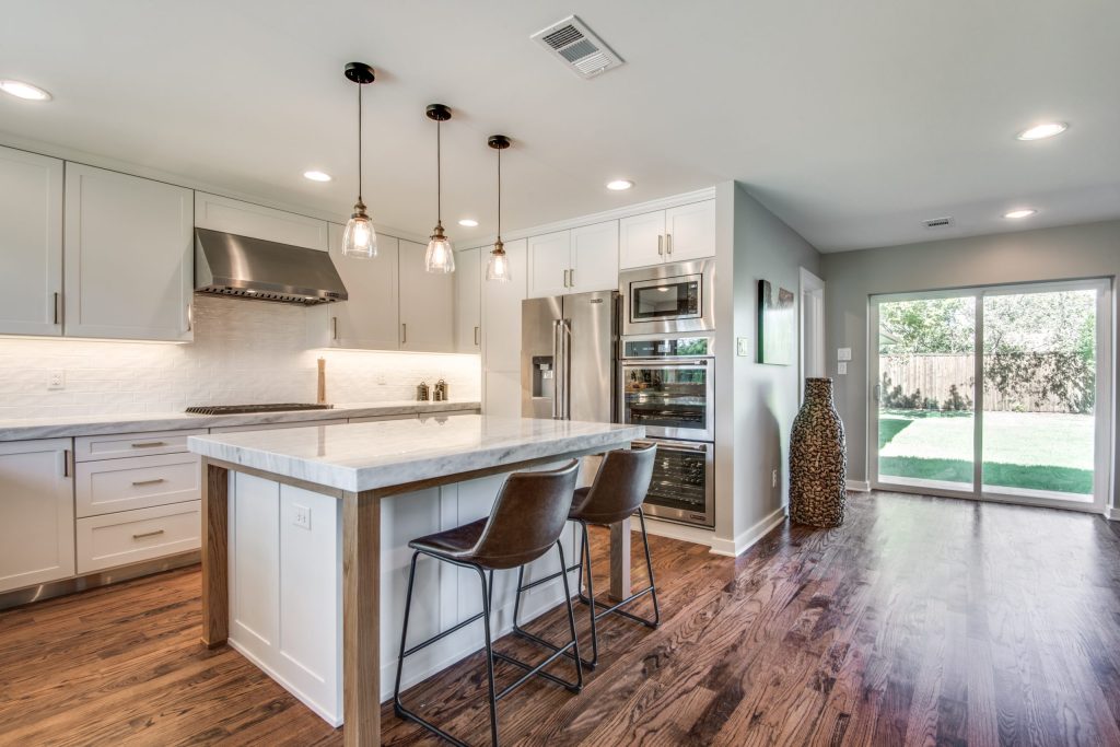 White kitchen with island seating open to the living space