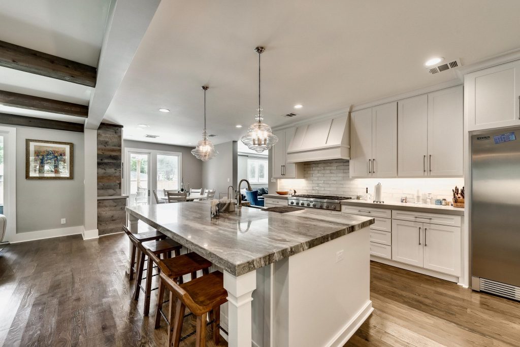 Kitchen with white island, open dining space and warm floors
