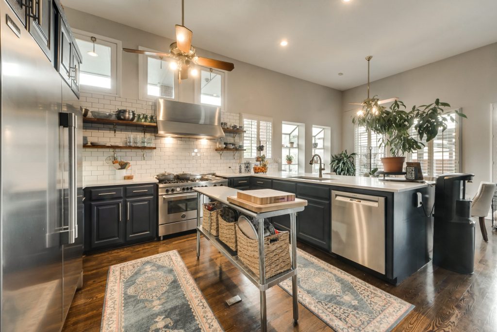 Kitchen with dark cabinetry, stainless appliances and stone countertops