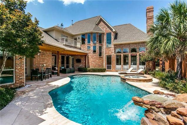 Dallas backyard with a curved pool and landscaped patio