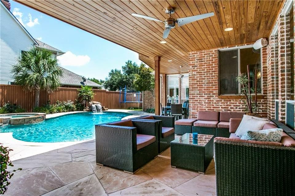 Covered patio beside a backyard pool