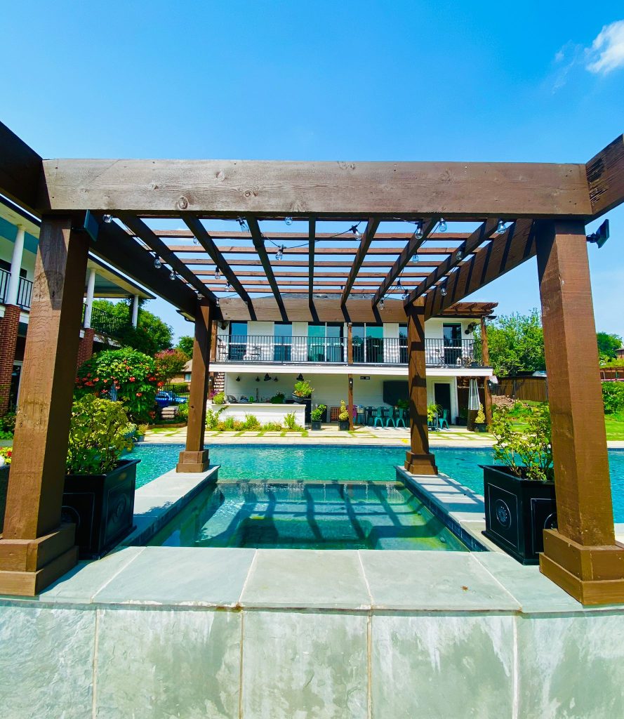 Pergola and patio beside a landscaped pool