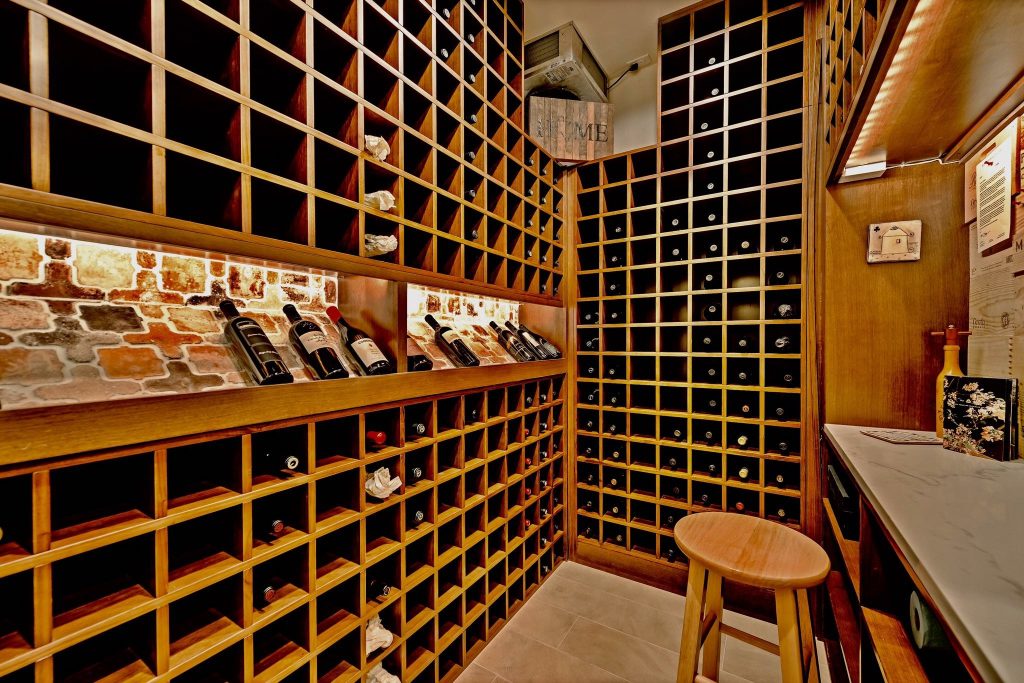 Warm wood wine cellar with custom bottle racks and bar counter