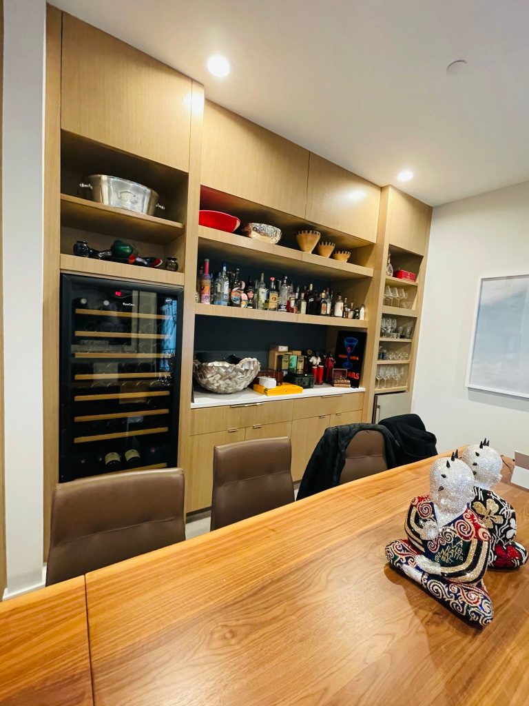 Built-in wine wall and display shelving beside a dining table