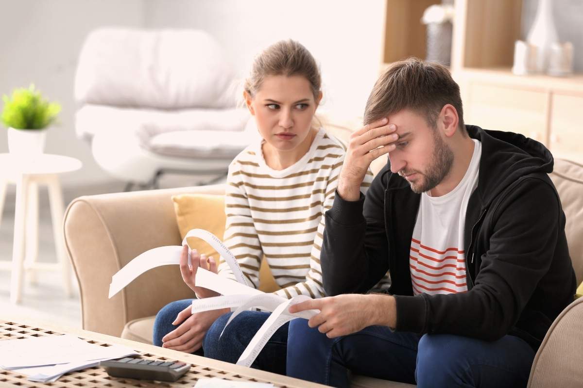 A couple looking stressed while reviewing home remodeling budget.