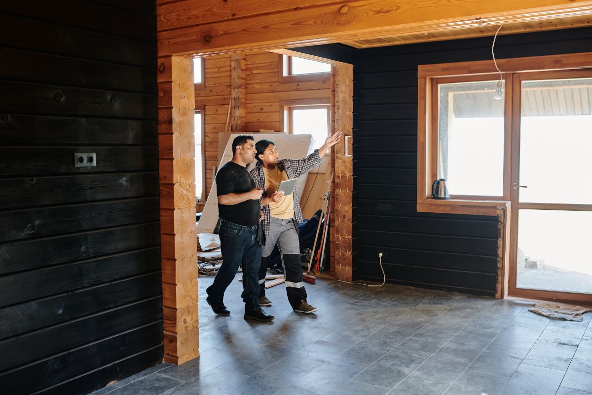 Home remodeling contractor discussing progress with client.