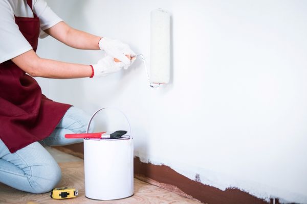 Man carefully applying paint on wall