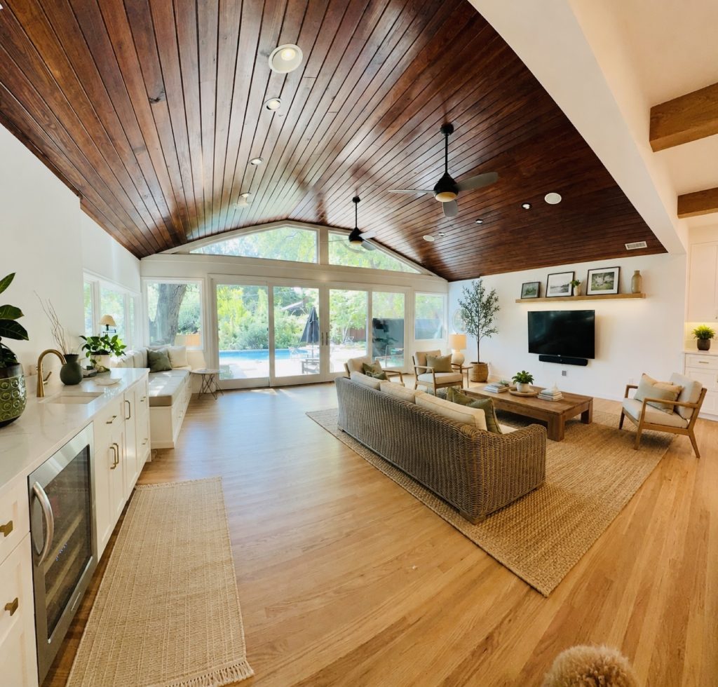Finished living room with a vaulted wood ceiling and doors opening to the pool
