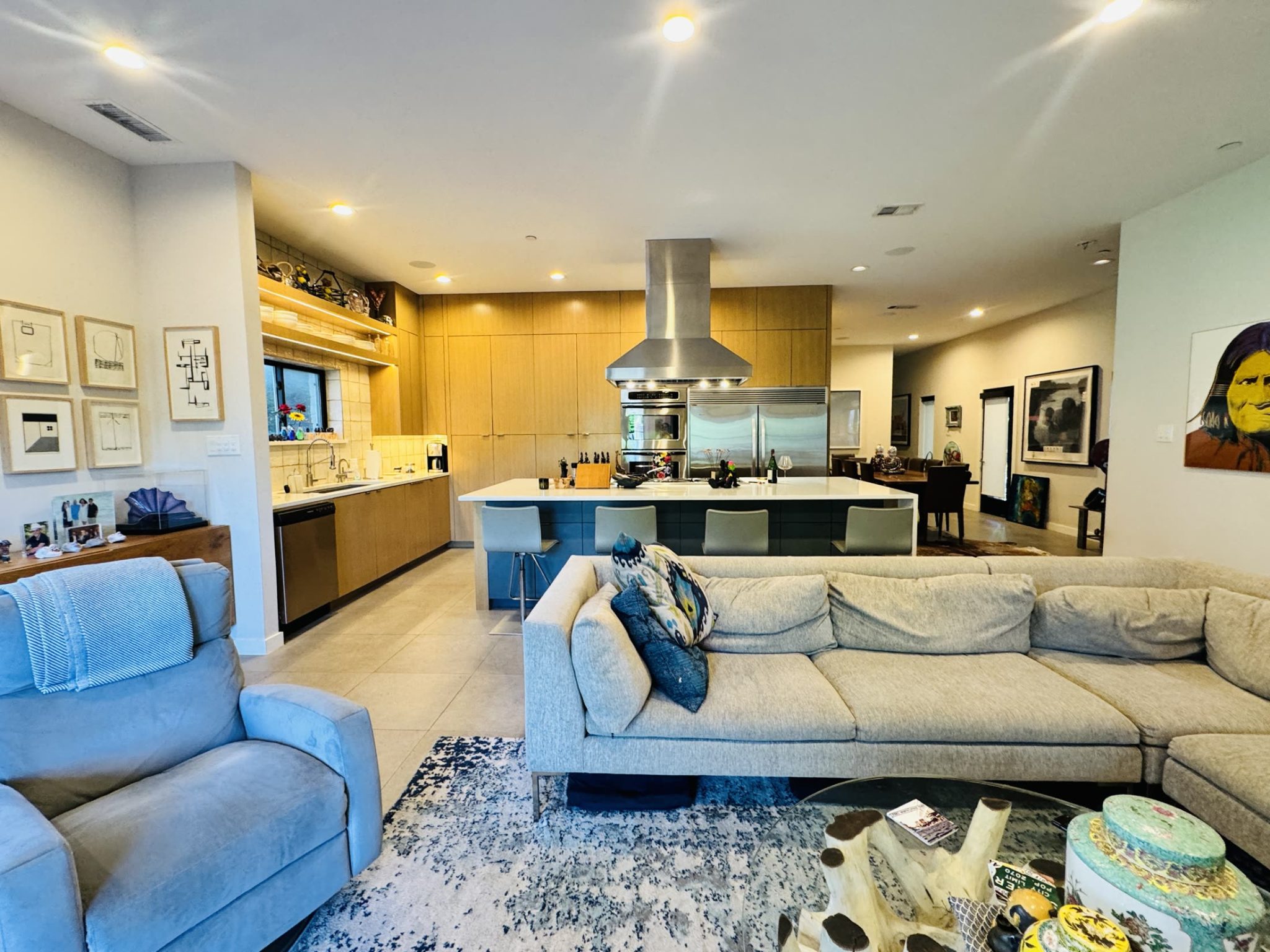 Homecorp living room connected to a warm wood kitchen with a large island